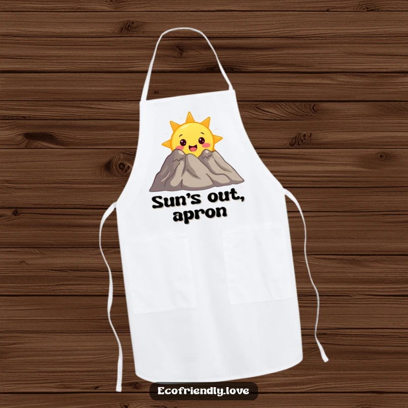 Funny apron featuring a surprised sun character peeking from behind a smiling mountain, a charming accessory for outdoor enthusiasts.
