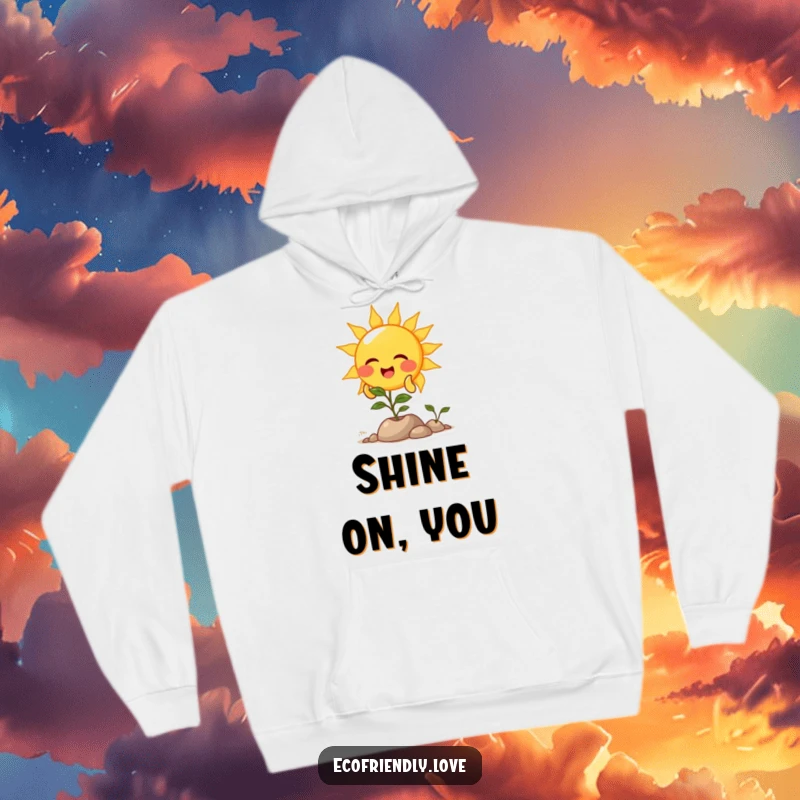 Funny hoodie featuring a smiling sun character showering light onto a thriving plant, offering cozy warmth and cheerful vibes.