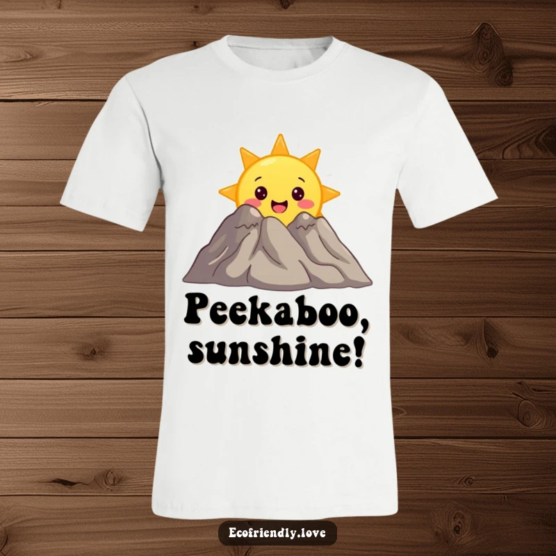 Funny t-shirt featuring a surprised sun character peeking from behind a smiling mountain, symbolizing discovery and joy.